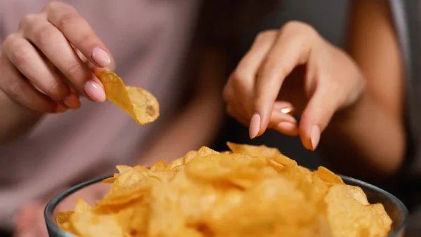 Twee vrouwen pakken chips uit een bak