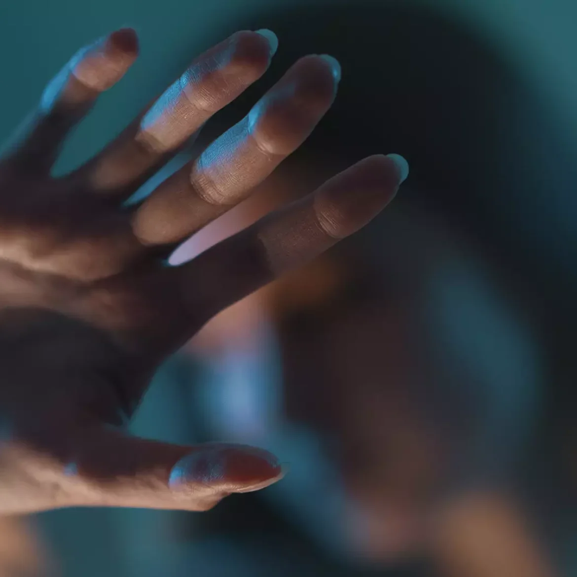 Vrouw houdt haar hand omhoog in een 'stop'-gebaar | Achtergrondartikel over femicide