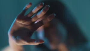 Vrouw houdt haar hand omhoog in een 'stop'-gebaar | Achtergrondartikel over femicide