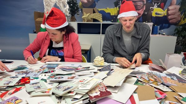 Kerstkaartjes uitzoeken aan een grote tafel