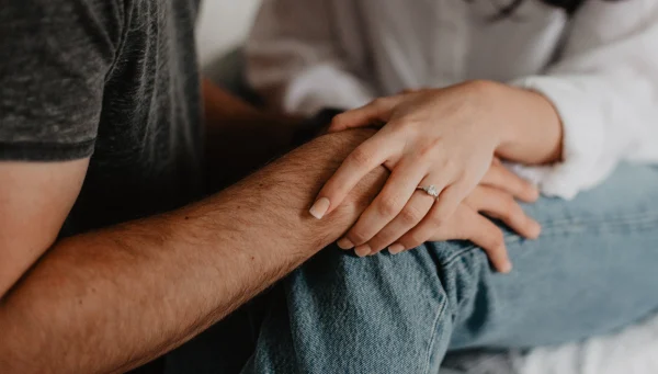 Man en vrouw houden elkaars hand vast