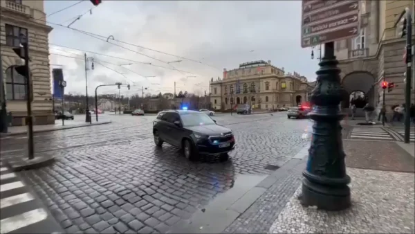 Een auto met zwaailichten blokkeert de toegang naar het plein in Praag waarop een schietpartij heeft plaatsgevonden