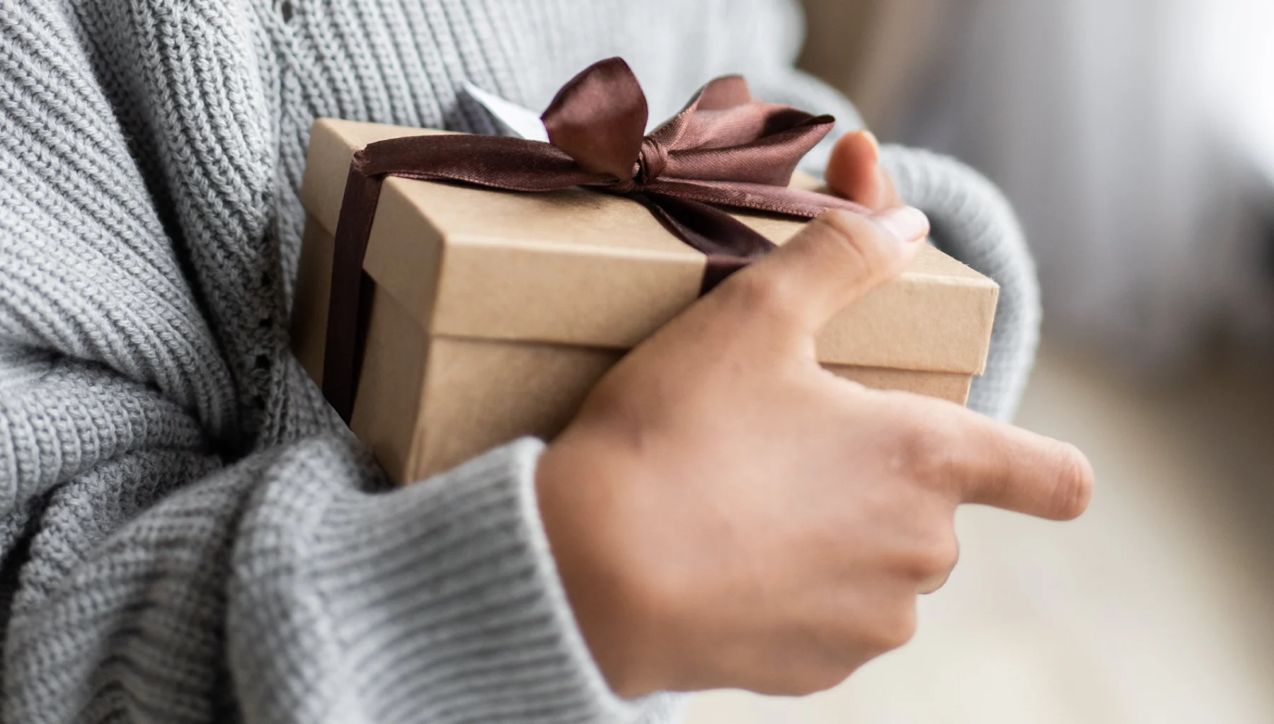 Iemand met cadeautje in zijn of haar handen