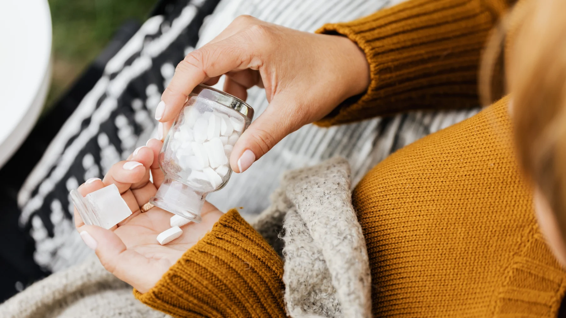 Vrouwenhand met een potje pillen medicijnen