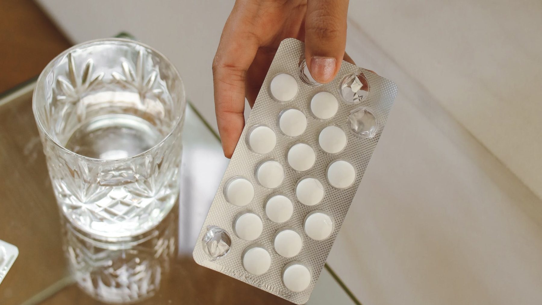 glas water en strip met witte pillen Middel X