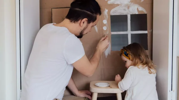 Bedrogen vrouw Julia: Je raadt nooit hoeveel kinderen hij had Foto: man is aan het knutselen met een kleuter.