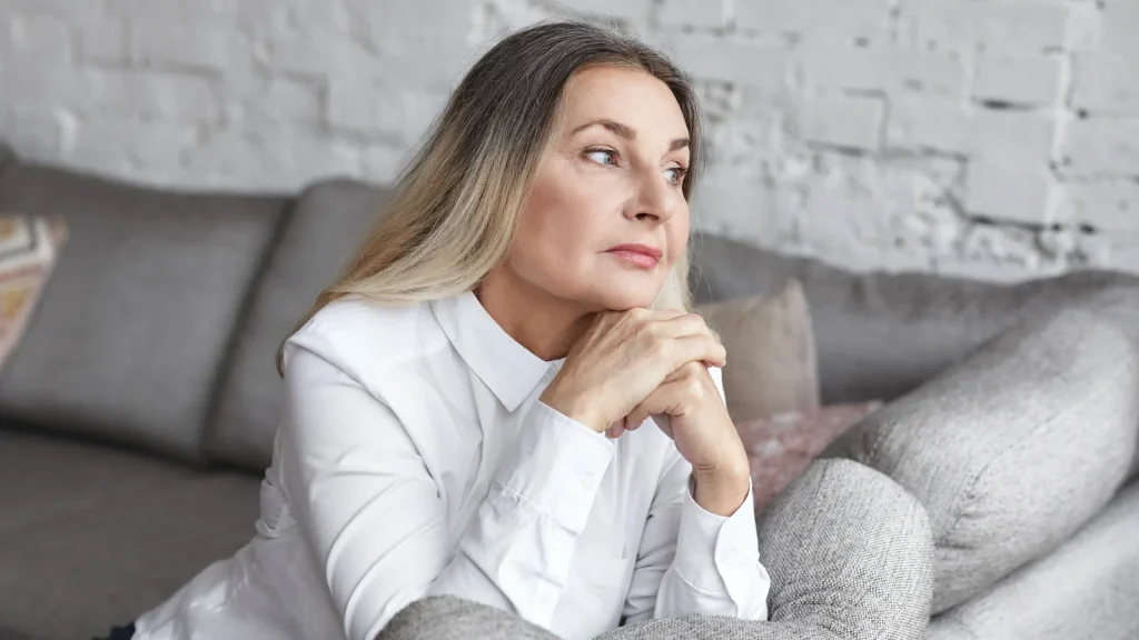 Vrouw kijkt peinzend voor zich uit | stiefkinderen