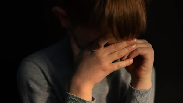 Jongen in kleine en donkere ruimte