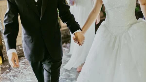 Foto van een bruidspaar dat hand in hand loopt op hun bruiloft