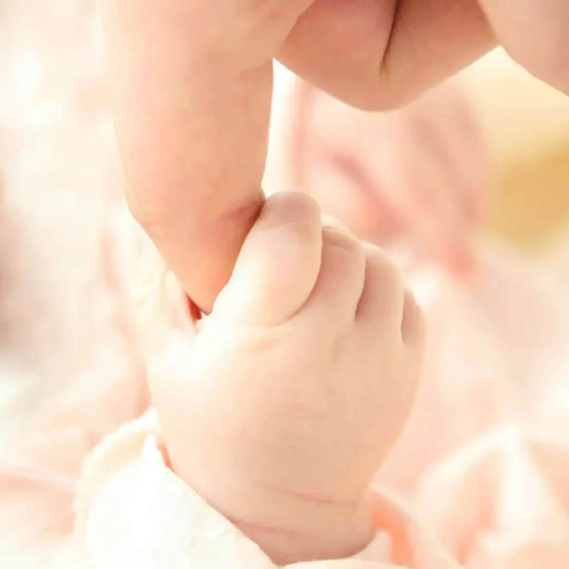 Baby houdt een vinger vast