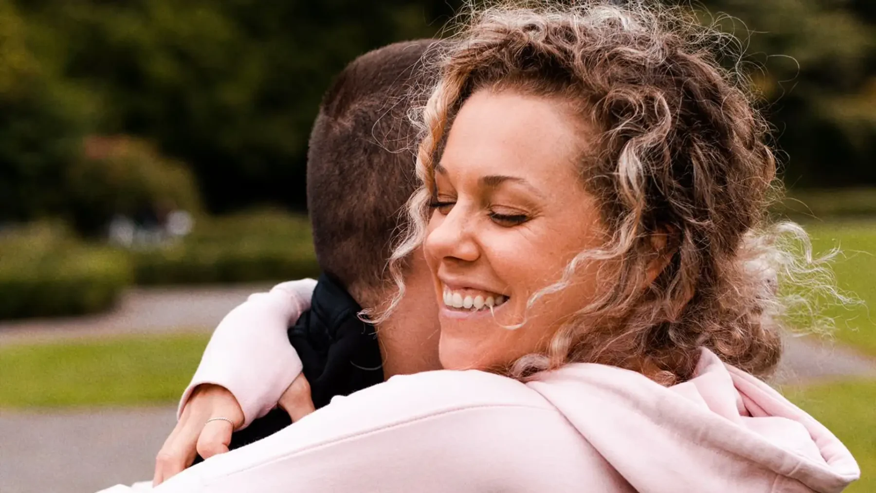 Knuffeltherapeut Laura Just lacht terwijl ze een man omhelst