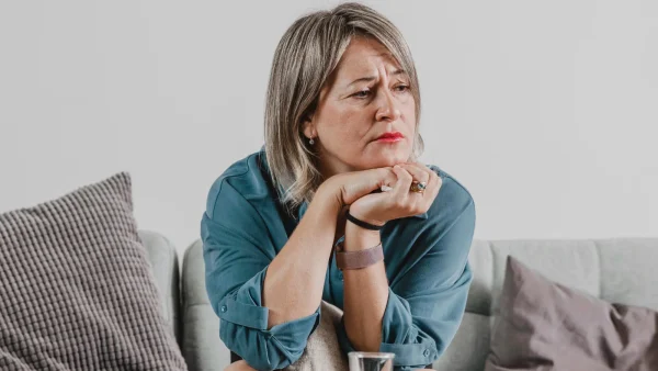 Vrouw met uitdrukking van innerlijke pijn op gezicht