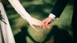 Foto van een bruidspaar dat elkaars handen vasthoudt, ter illustratie