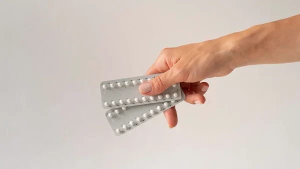Vrouw houdt pillenstrips vast. Mannenpil is er nog niet