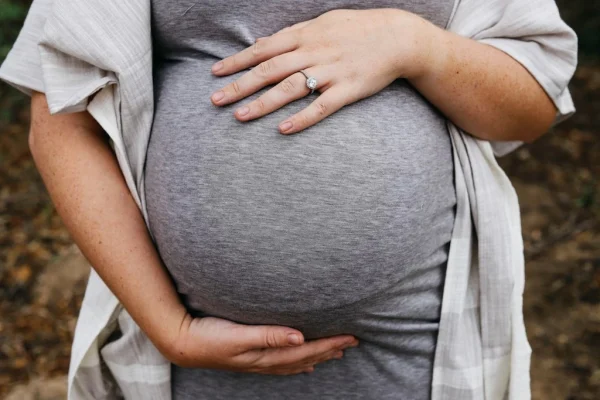vrouw houdt zwangere buik vast