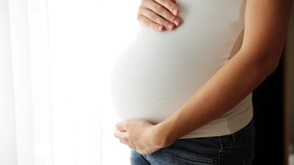 Vrouw houdt zwangere buik vast waar baby in zit