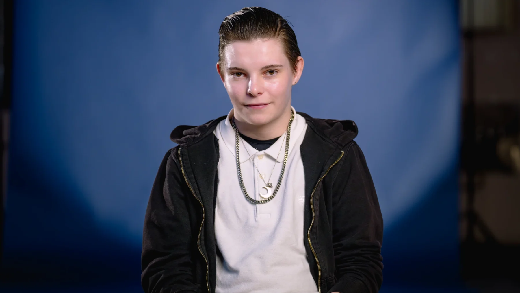 Noah in wit t-shirt, gouden ketting en zwart vest