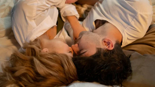 Vrouw en mannen liggen in bed met de neuzen tegen elkaar | High class dates jacky en bo