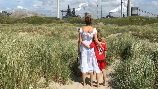 Stephanie Dumoulin (48) en haar zoon (10) op het strand vlak bij de fabrieken van Tata Steel