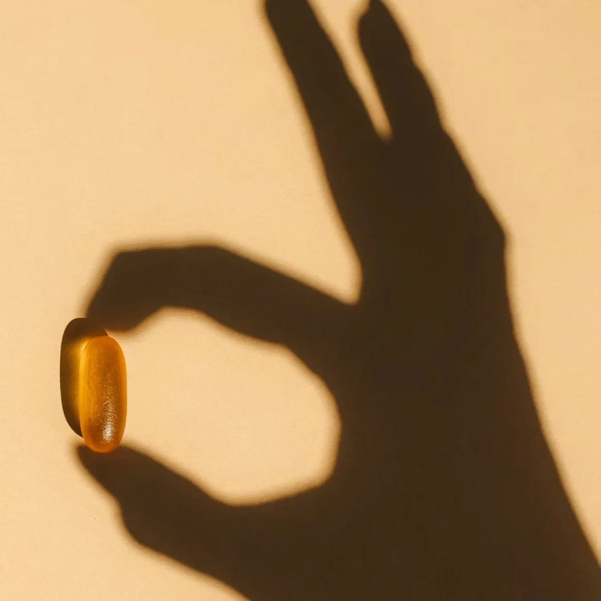 Schaduw hand houdt vitamine D pil vast