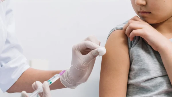 Kind wordt gevaccineerd door dokter