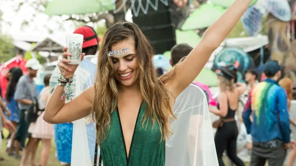 Vrouw danst op festival met drankje in haar hand