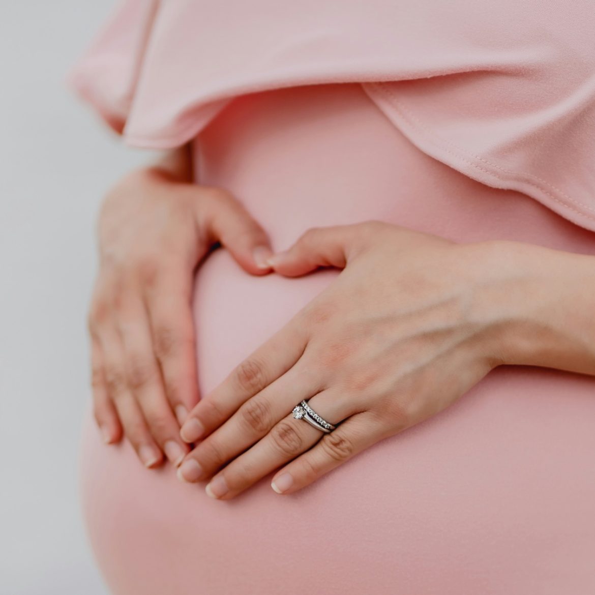 Zwangere vrouw met handen op buik