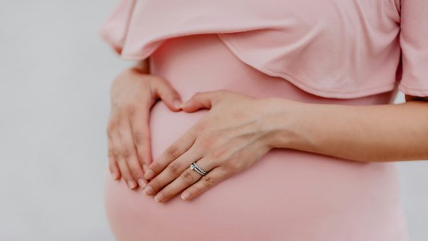 Zwangere vrouw met handen op buik