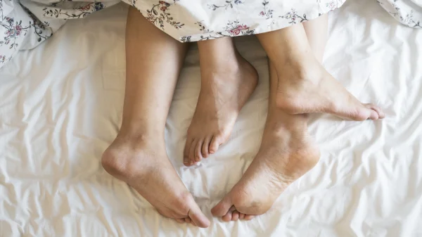 voeten van een man en een vrouw in een bed