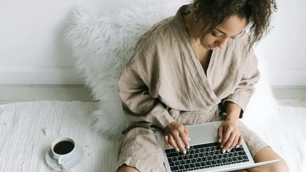 Vrouw op bed met laptop