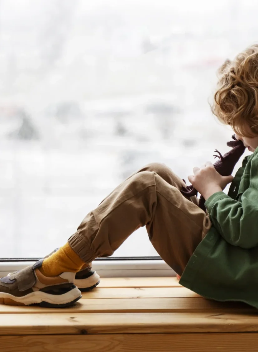 Kind kijkt naar buiten vanuit vensterbank