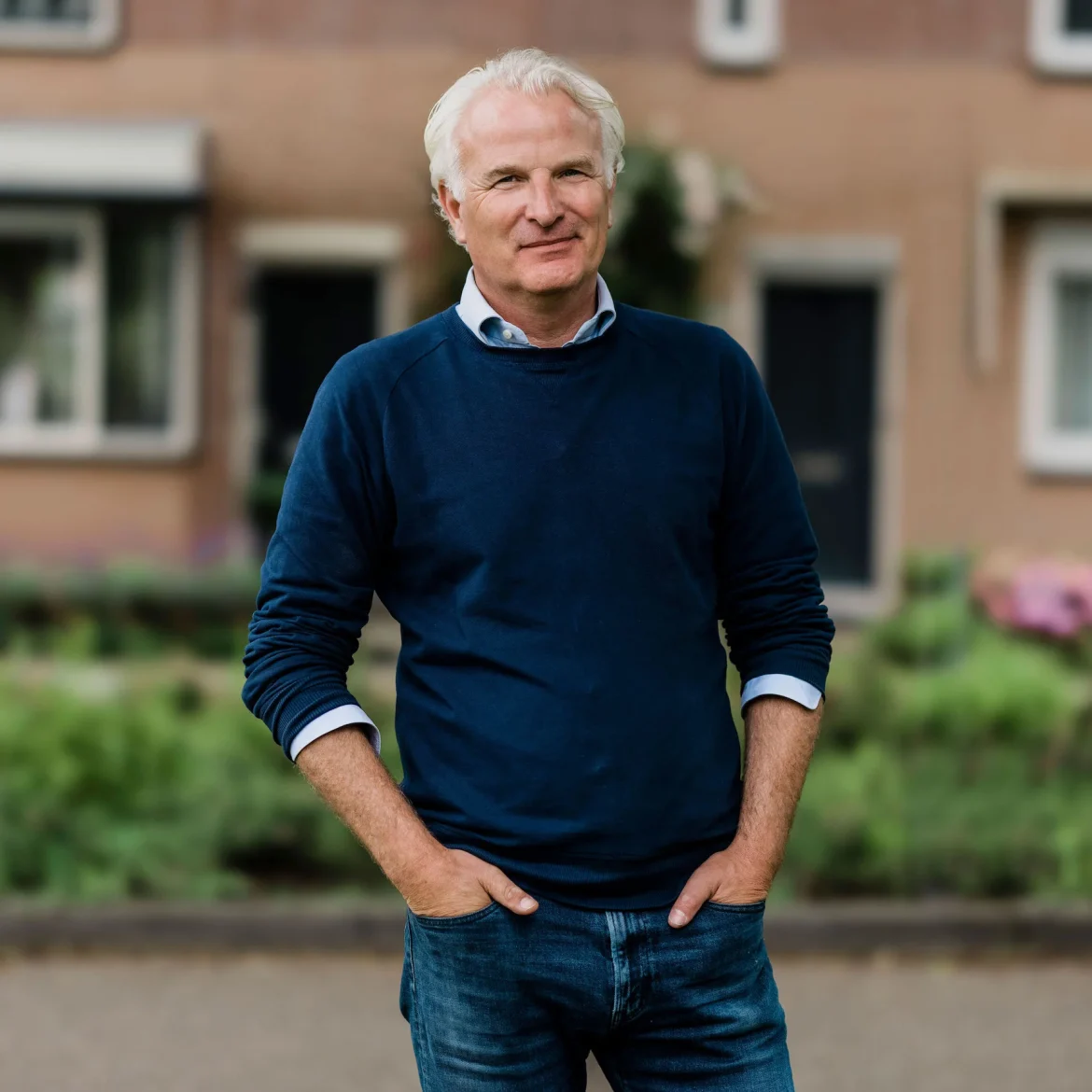 bob sikkes in donkerblauwe trui op straat voor een woning