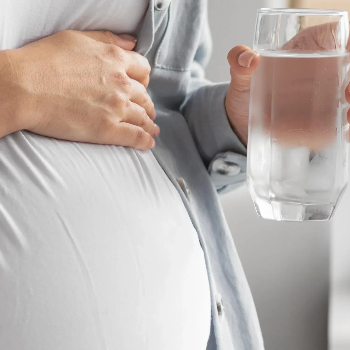 Zwangere vrouw drinkt water voor medicatie