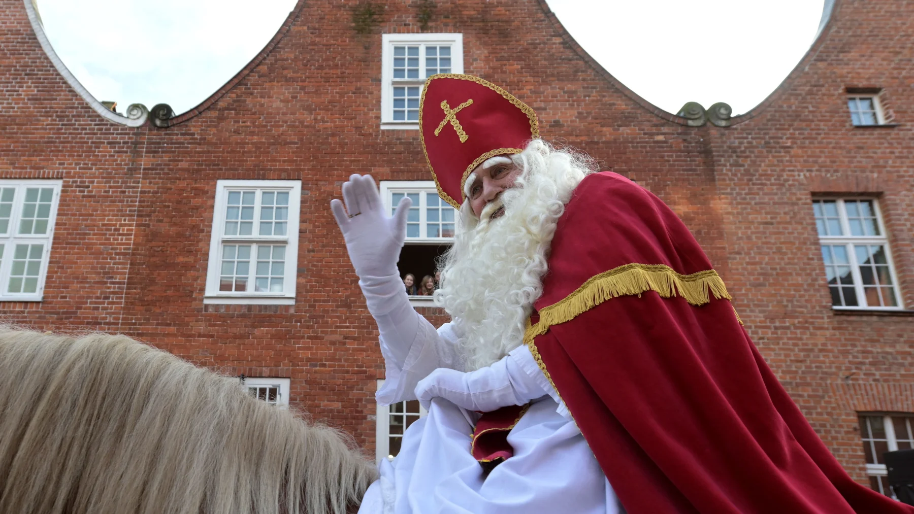 Sinterklaas te paard zwaaiend tijden Sinterklaas intocht