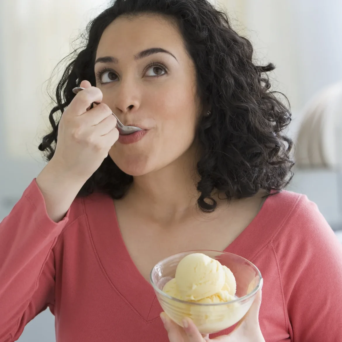 Vrouw eet ijs uit de vriezer