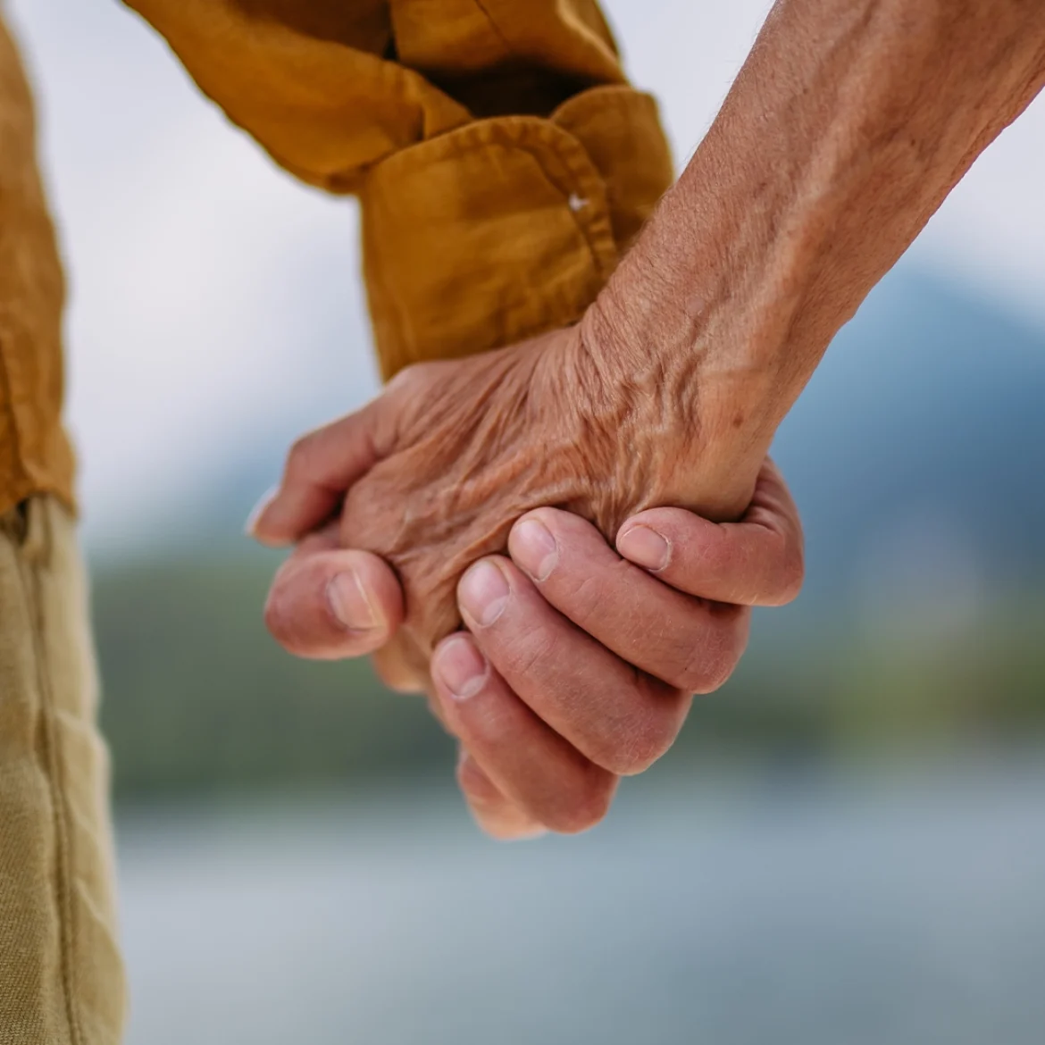 Oudere mensen houden elkaars hand vast