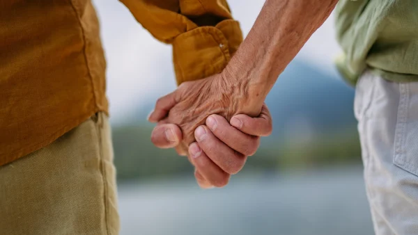 Oudere mensen houden elkaars hand vast