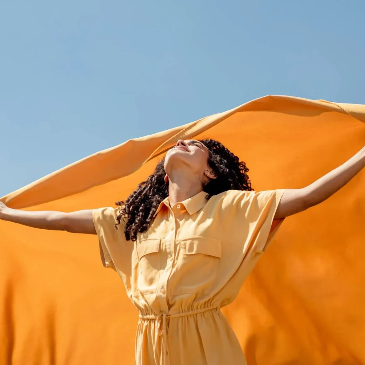 Vrouw in de zon met oranje doek