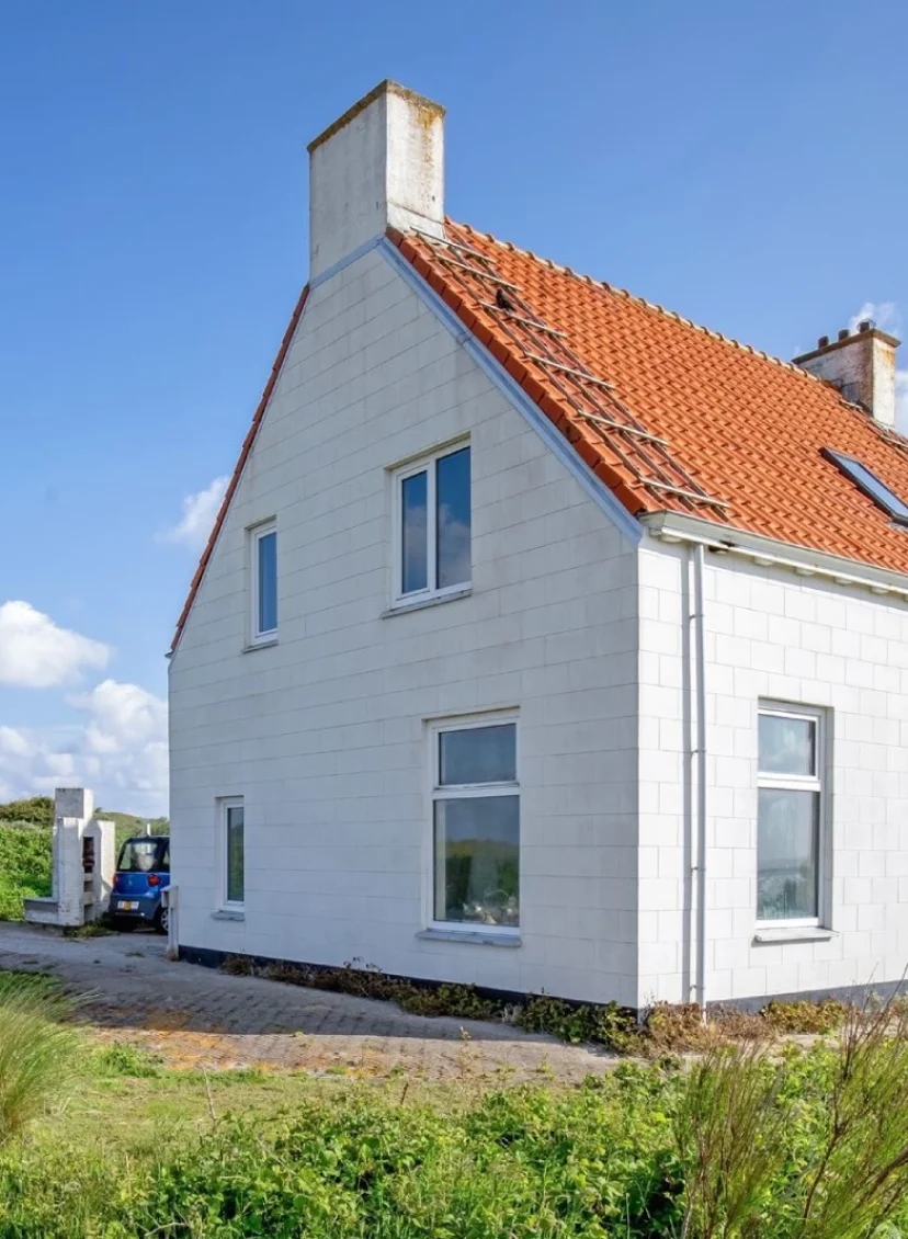Wit huis op een groene vlakte naast de vuurtoren van Texel