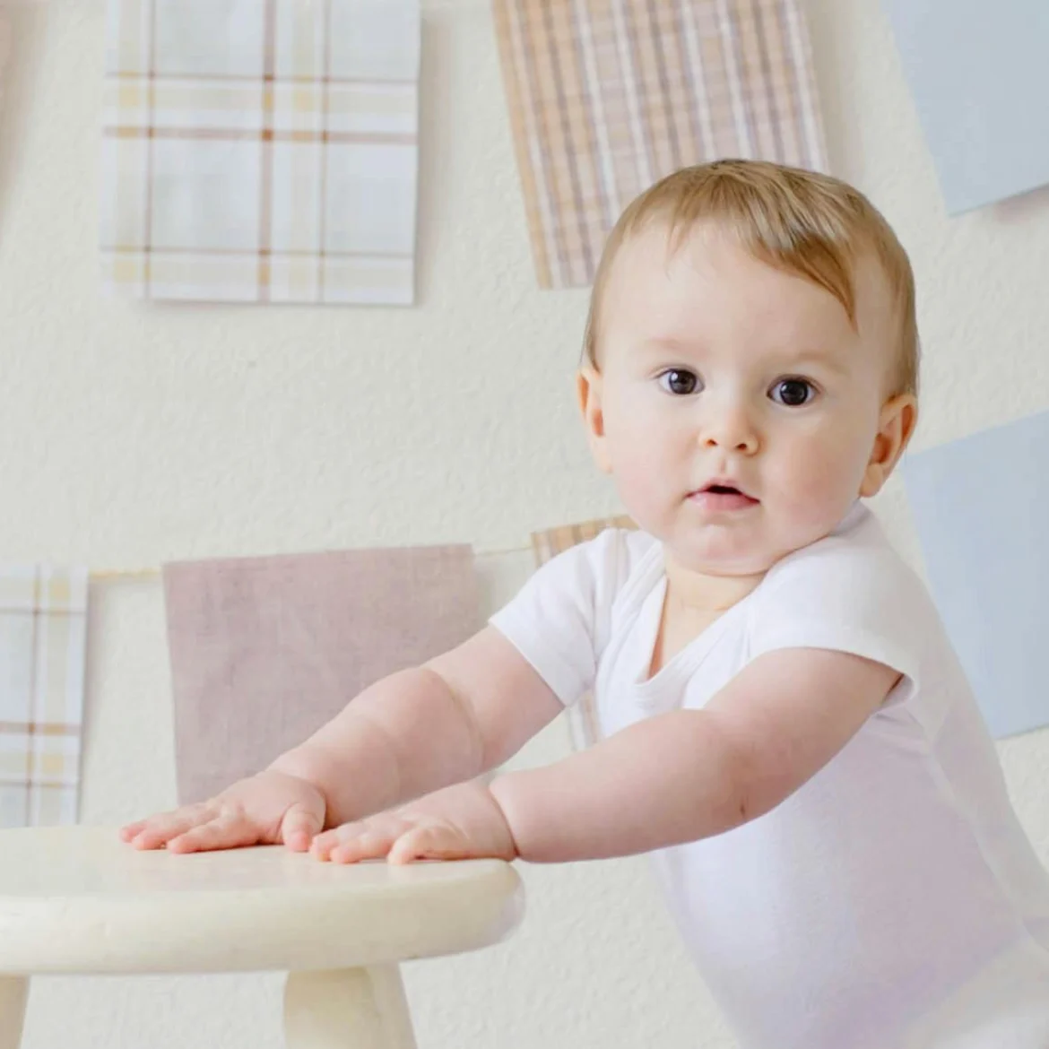 baby staat bij krukje