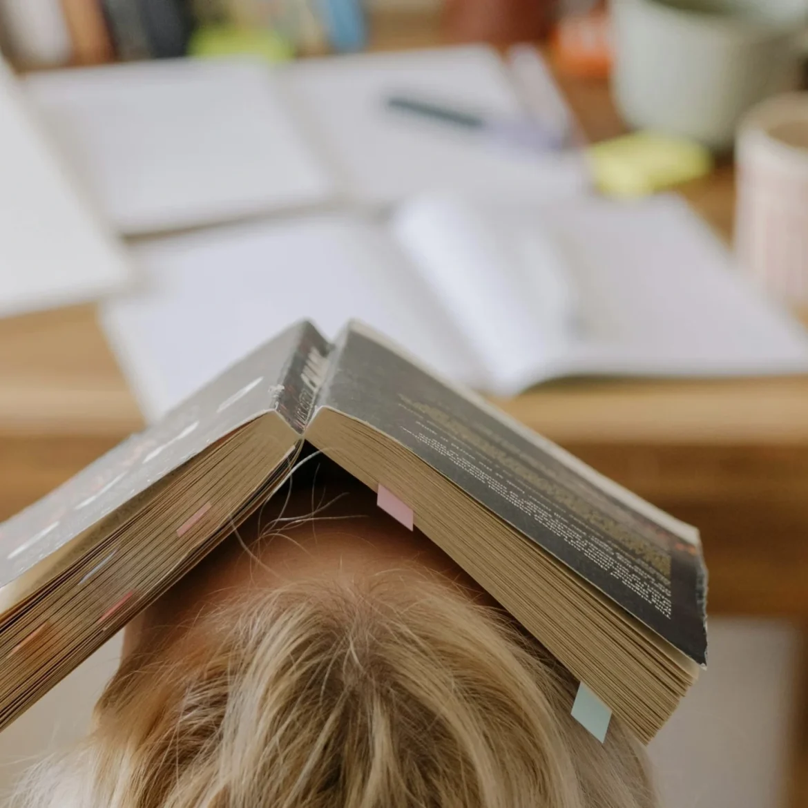 Dame met boek op haar hoofd en schoolboeken in de achtergrond