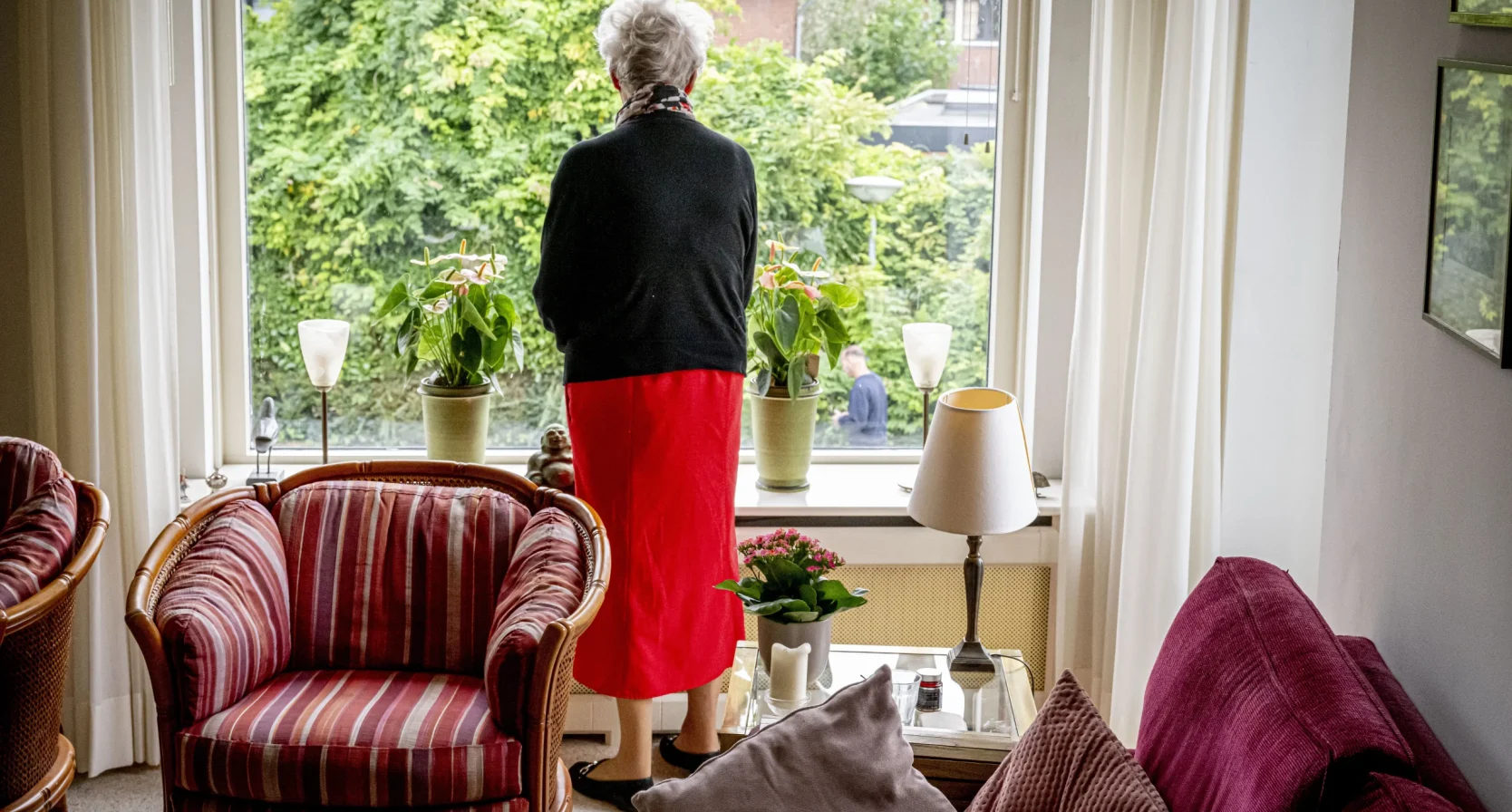 Oudere vrouw voor het raam