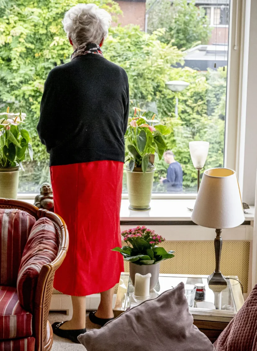 Oudere vrouw voor het raam