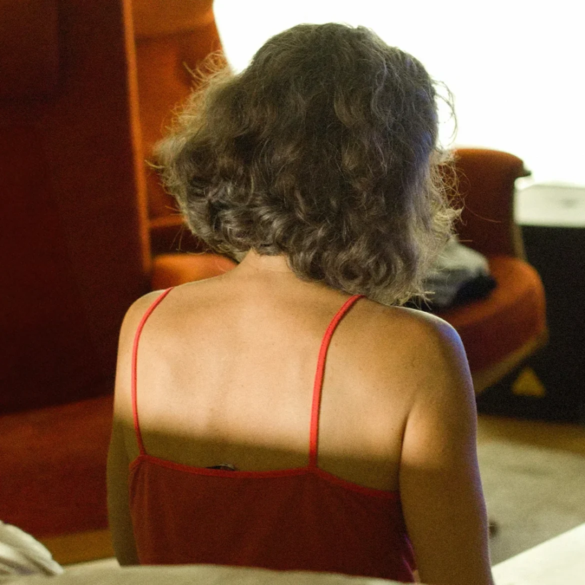 Vrouw met haar rug naar de camera, kijkt naar beneden