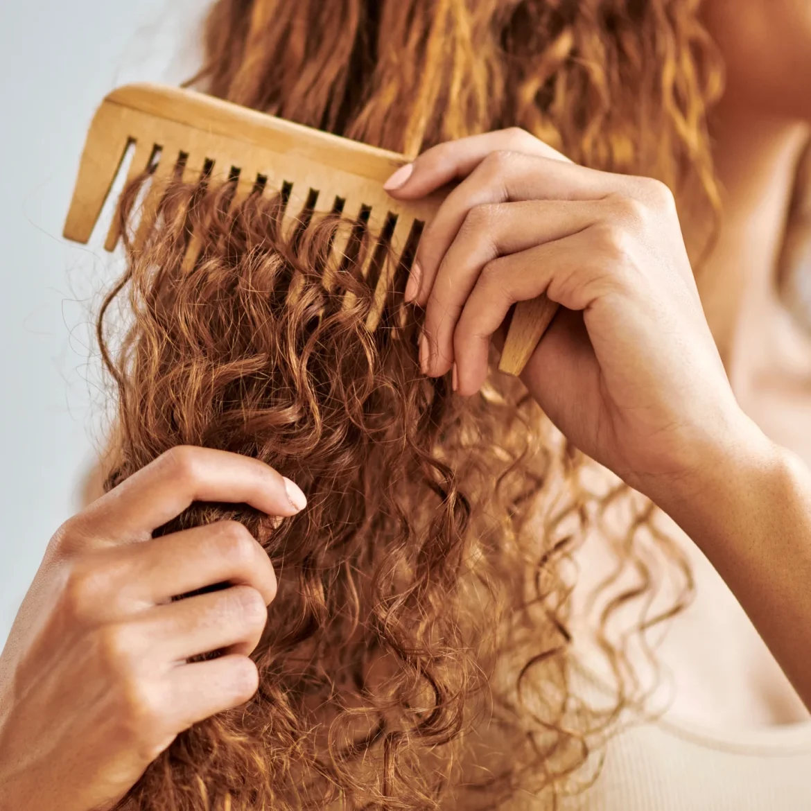Vrouw met rode krullen kamt haar haren