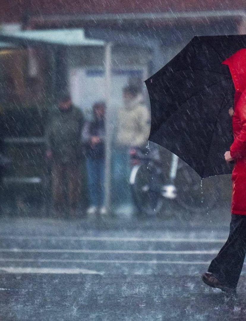 vrouw met paraplu in regen