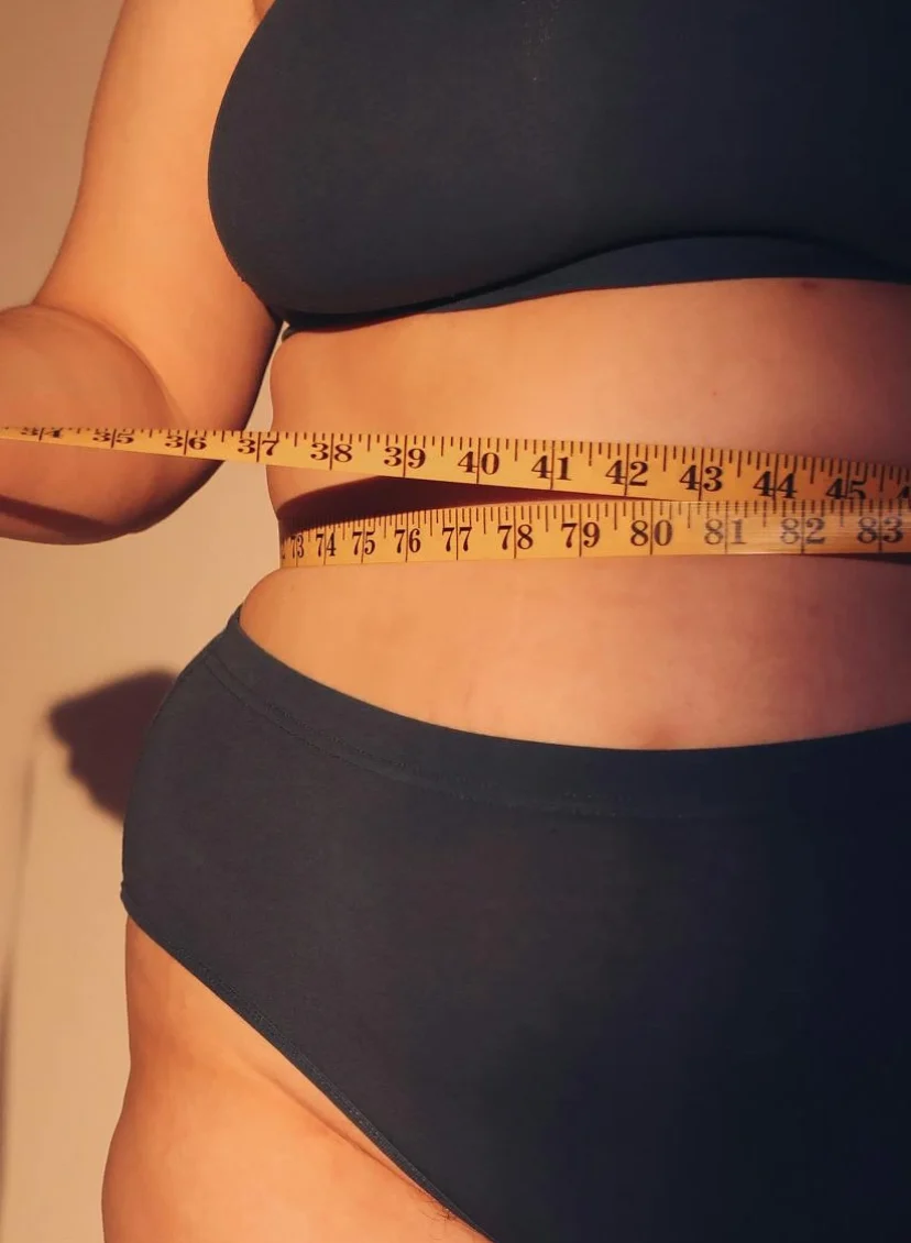 Vrouw in ondergoed met meetlint