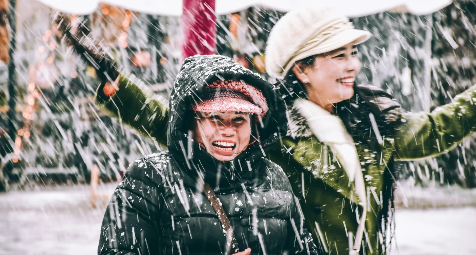 Twee vrouwen lachen in de sneeuw