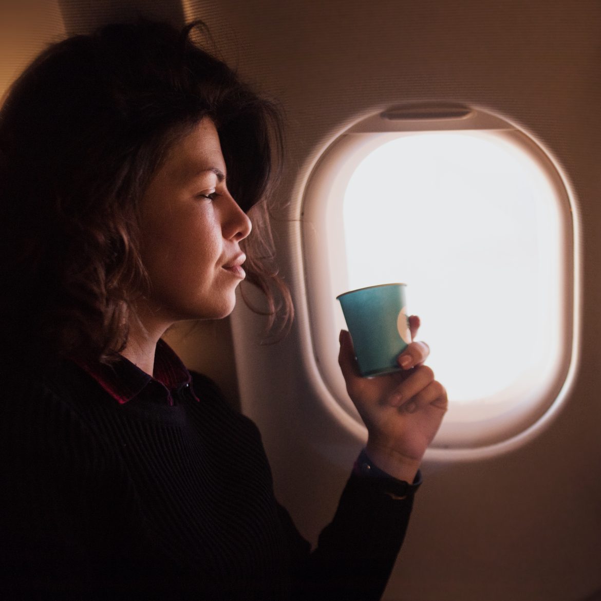 Vrouw drinkt koffie in het vliegtuig