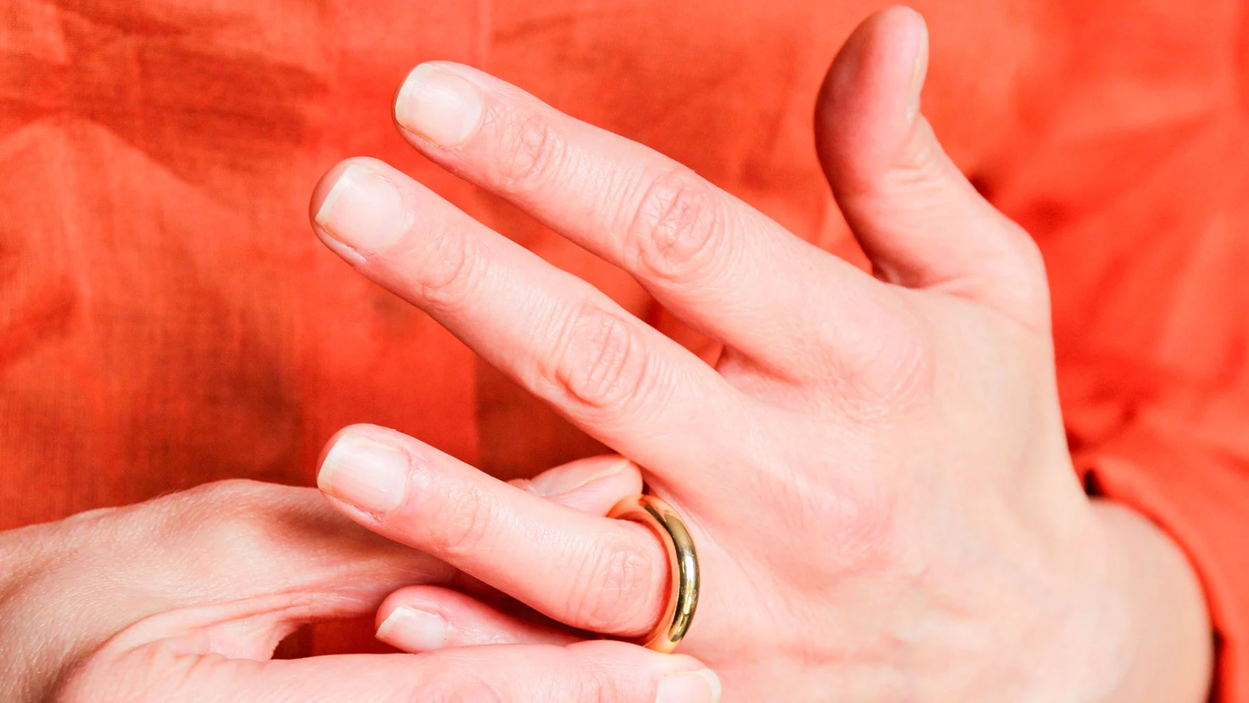 Bedrogen vrouw | twee handen die een trouwring afdoen